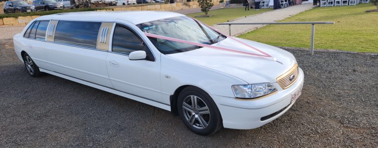white 9 seater limo parked near the ceremony